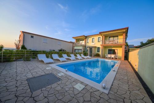 维尔Sunset Deluxe Villa的一个带躺椅的游泳池以及一座房子
