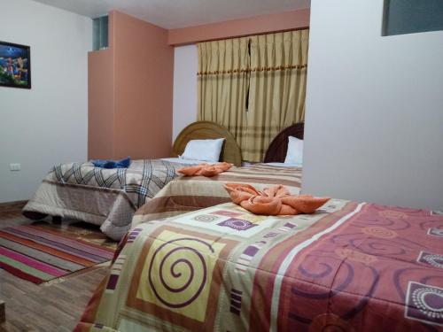 普诺Hostal Intiwatana Inn的客房内的两张床和毛巾