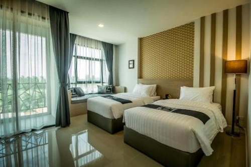 华欣特里普Z酒店的酒店客房设有两张床和窗户。