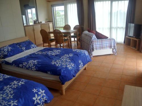 石垣岛野底海滩乡村酒店的一间卧室配有两张床和一张桌子及椅子