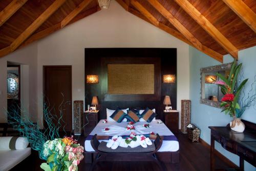 拉迪格岛乐尔休闲海滨别墅的一间卧室配有一张带鲜花的大床