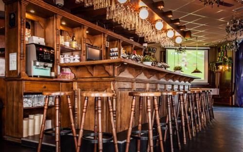 布林瑟姆Rumpenerhof的餐厅内带木制酒吧凳的酒吧