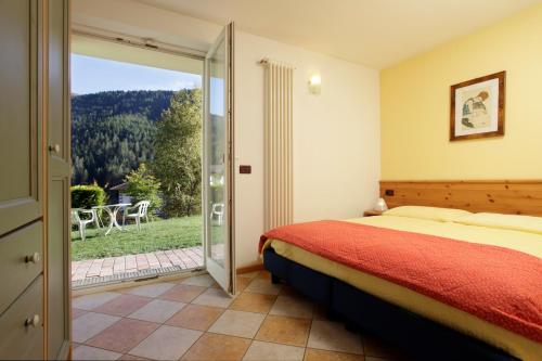 梅扎纳Villa Verde的一间卧室设有一张床和一个滑动玻璃门