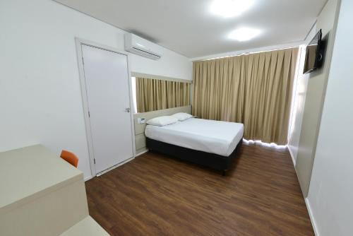 伊帕廷加Hotel Panorama Economic的小房间设有床和电视