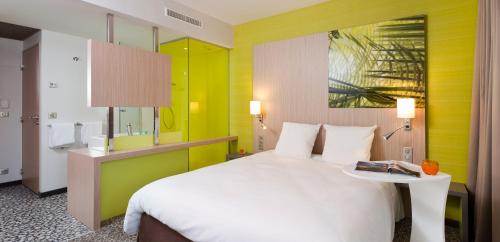 特鲁瓦ibis Styles Troyes Centre的酒店客房设有一张大床和一张桌子。