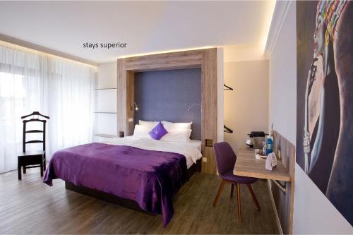 多特蒙德多特蒙德住宿设计酒店的一间卧室配有一张床和一张桌子及椅子