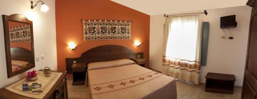 包内伊比亚玛莱酒店的一间卧室配有一张床、镜子和窗户