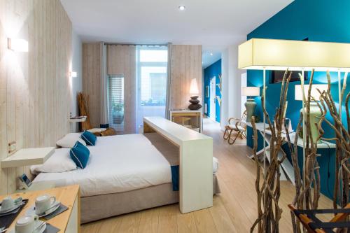 第戎Résidence des Ducs的一间卧室设有一张床和蓝色的墙壁