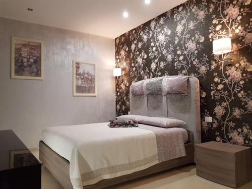 圣塞韦罗Le Cale' B&B的一间卧室配有一张带花卉壁纸的床