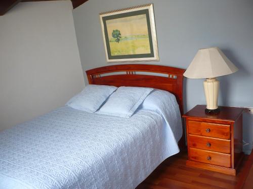 基多途塔曼达2旅馆的一间卧室配有一张床,梳妆台上配有一盏灯