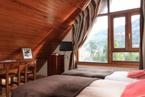 萨连特加列戈Hotel-Aparthotel El Reyno的一间卧室配有一张床、一张书桌和一个窗户。