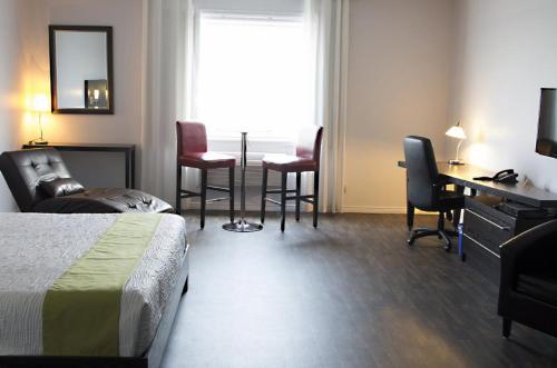 DegelisHôtel-Motel 1212的酒店客房带一张床、一张桌子和椅子