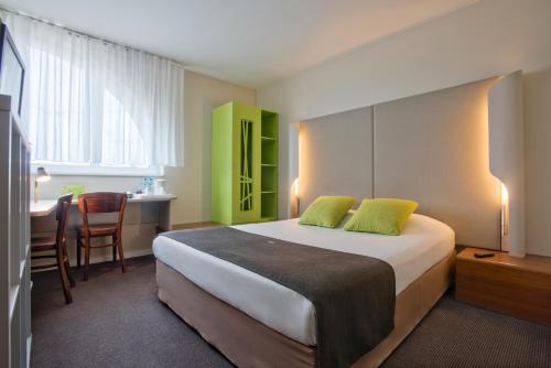 罗兹钟楼罗兹酒店的酒店客房配有一张床、一张书桌和一间厨房。