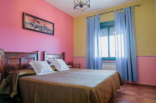 鲁伊德拉洛斯潘秋斯公寓的一间卧室配有一张粉红色的墙壁和窗户。