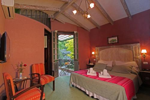 查克拉斯德科里亚卡萨格力比尼雅斯酒店的一间卧室设有一张带红色墙壁的大床