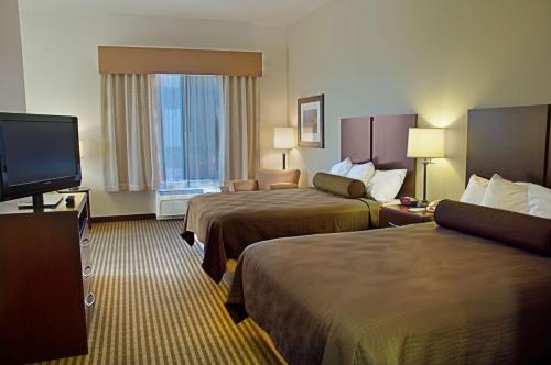 梅萨Legacy Inn & Suites的酒店客房设有两张床和一台平面电视。