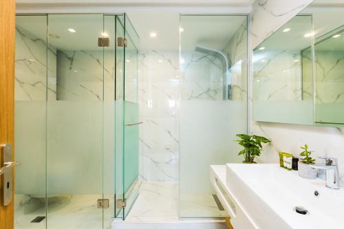 罗希姆诺Menta City Boutique Hotel的一间带玻璃淋浴和水槽的浴室
