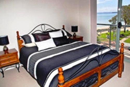罗金汉姆海滩浮桥酒店的一间卧室设有一张床,享有海景