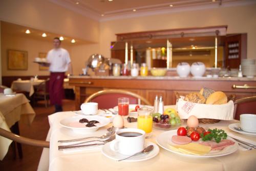 汉堡埃尔斯特酒店的一张带早餐食品的桌子和一个背景的人