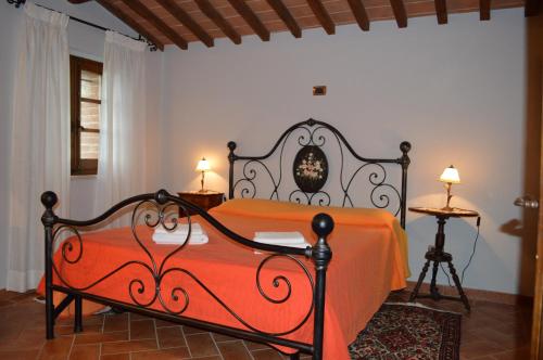 阿夏诺Casa Vacanze Il Fornacino的一间卧室配有一张带橙色床罩的床