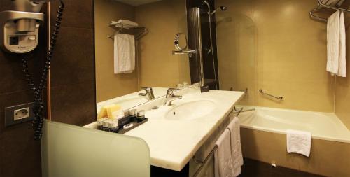 福米加尔HG阿尔拓阿拉贡酒店的浴室配有盥洗盆和浴缸。