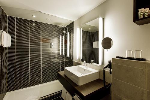 维尔茨堡维尔茨堡麦纽夫美居酒店的一间带水槽和镜子的浴室