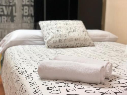 萨拉曼卡托莱克拉维洛公寓的两张带白色床单和毛巾的床