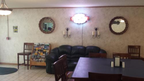 Mound CityAudrey's Motel的一间设有真皮沙发、桌子和镜子的等候室