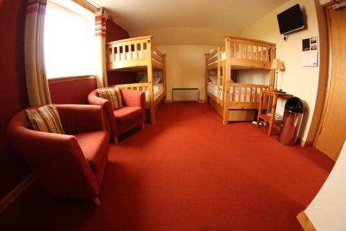 柯克沃尔Orcades Hostel的客房设有两张双层床和红地毯。