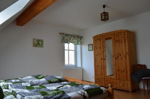 GrebensteinFerienwohnung Jäger的一间卧室配有一张床和一个木制橱柜