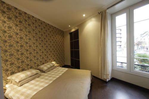 尼斯Apartment with strong WiFi and parking in Nice near the harbor的一间卧室设有一张床和一个大窗户