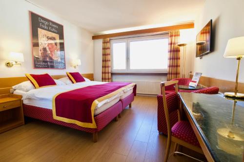 锡永罗纳酒店的酒店客房设有一张大床和一张书桌。