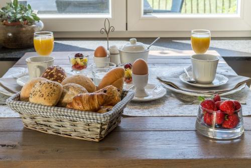Rijkevorsel里克鲁斯特住宿加早餐酒店的一张桌子,上面放着一篮面包、鸡蛋和草莓
