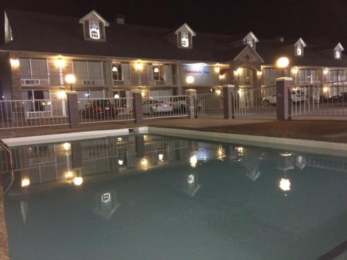 罗兰Interstate Inn的一座游泳池,在晚上在建筑物前