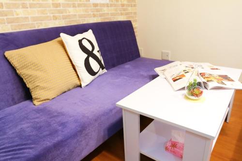 广岛广岛袋町千鸟公寓的紫色沙发,配有枕头和桌子
