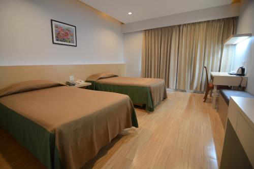 乌隆他尼切伦酒店的酒店客房配有两张床和一张书桌
