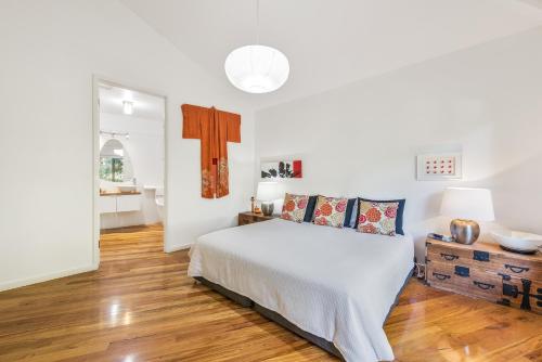 马里斯维尔达林普尔斯来宾小屋酒店的一间铺有木地板的白色卧室,配有一张床