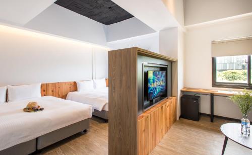 台东旅人驿站 - 铁花文创馆的酒店客房设有两张床和一台平面电视。