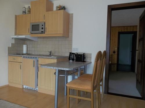 HausenFerienwohnung Günschmann的厨房配有木制橱柜和桌椅