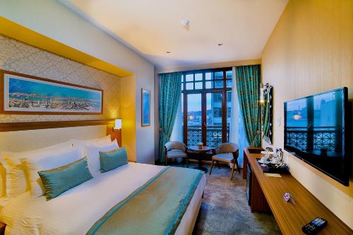 伊斯坦布尔时代报金角湾酒店的酒店客房设有一张大床和一台电视。