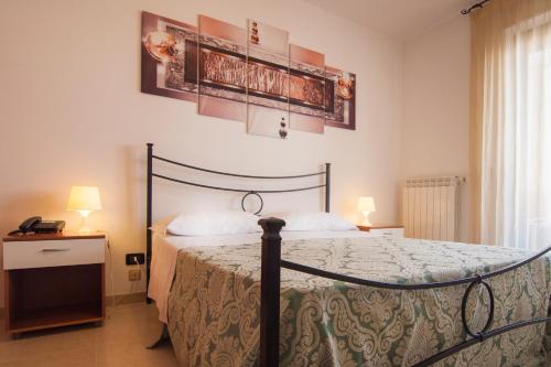 孔韦尔萨诺Ciao Hotel & Residence的卧室配有一张床和墙上的两张海报