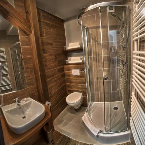 大波兰地区奥斯特鲁夫Hotel Górecznik的带淋浴、盥洗盆和卫生间的浴室