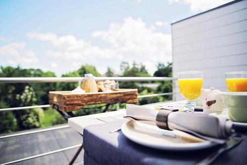 哈瑟尔特德斯鲁斯别墅住宿加早餐酒店的一张桌子,上面放着一盘食物和两杯橙汁