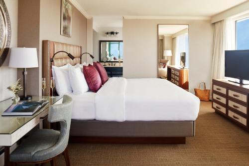 利斯堡兰斯当度假酒店及Spa的一间卧室配有一张床、一张书桌和一台电视