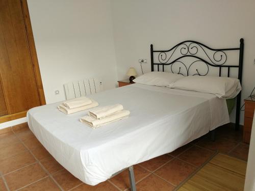 拉斯内格拉斯Apartamento Los Olivos的卧室配有白色的床和2条毛巾