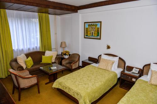 瓦列沃格兰德酒店的酒店客房配有一张床、一张沙发和椅子。