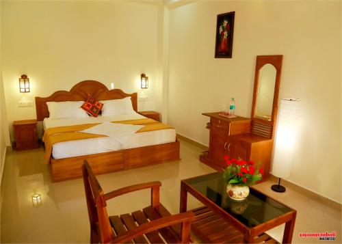 提喀迪Holiday Villa的酒店客房配有一张床和一张桌子,桌子上装有四面 ⁇ 
