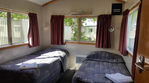 特威泽尔哈爱乡村旅馆，汽车旅馆&背包客栈的一间卧室设有两张床和两个窗户。