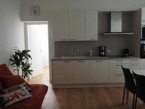 斯特拉斯堡Appartement place Golbéry的一间厨房,内设白色橱柜和沙发