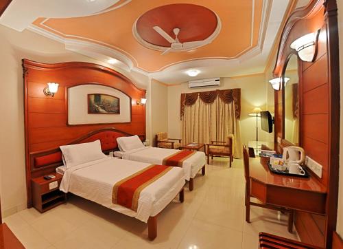 坦贾武尔那南酒店的酒店客房配有两张床和一张书桌